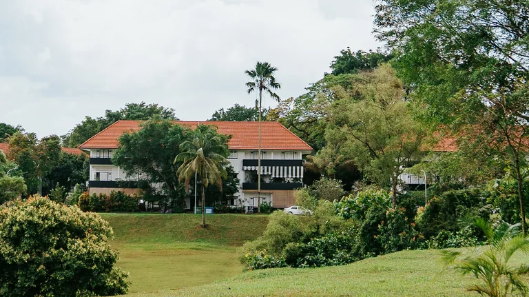 Photograph: a conserved black-and-white house with a red-tiled roof on the sloping lawns of the Wessex estate, near Bloomsbury Residences